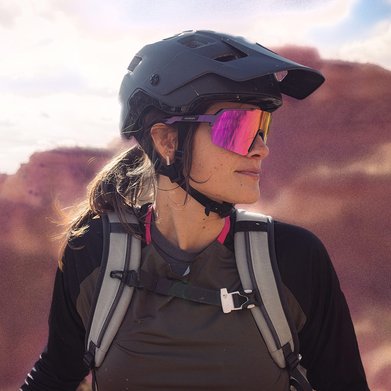 Sportlerin mit Helm und pinker Sportsonnenbrille beim Outdoor-Abenteuer