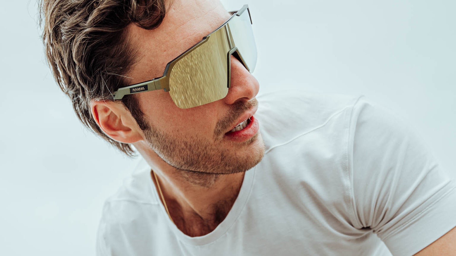 Stilvolle Nahaufnahme eines Athleten in trendiger goldener Sonnenbrille und weißen Shirt